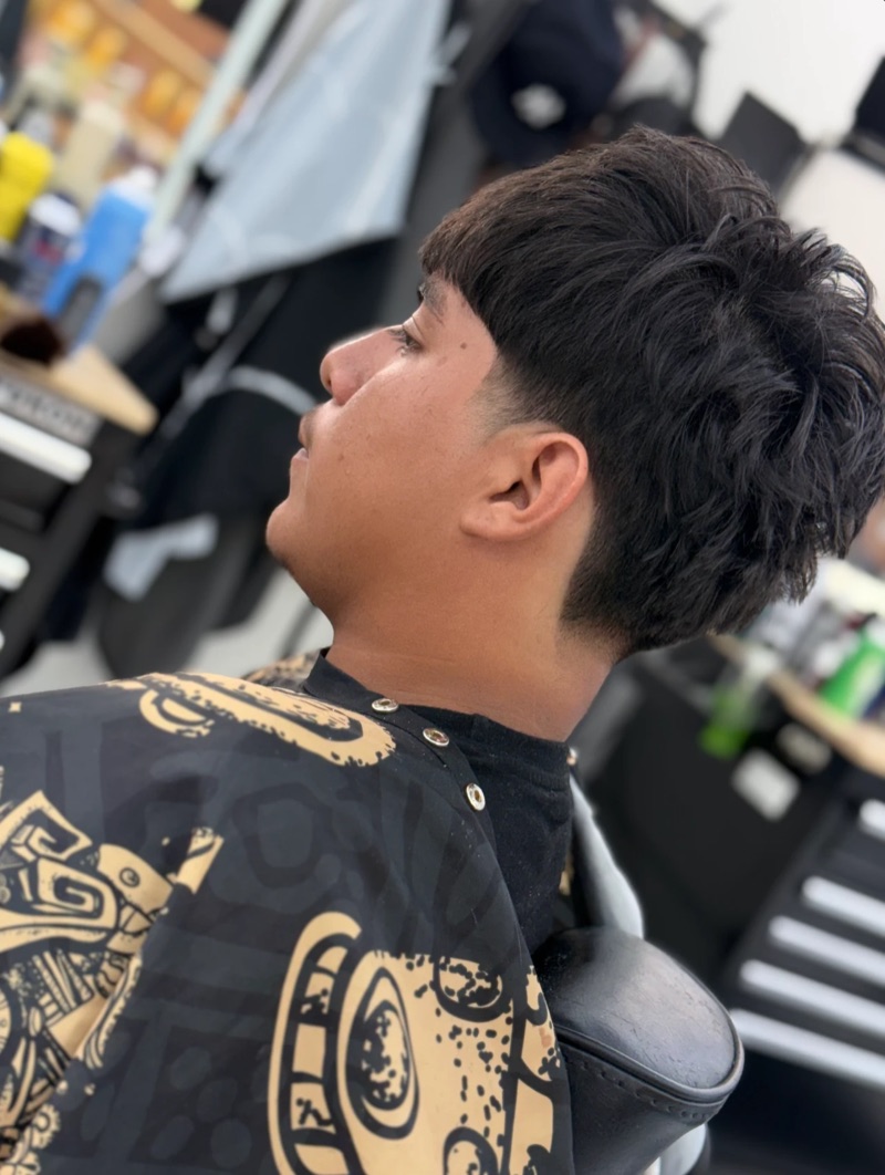 Side profile of a low taper with a textured fringe and a clean neckline