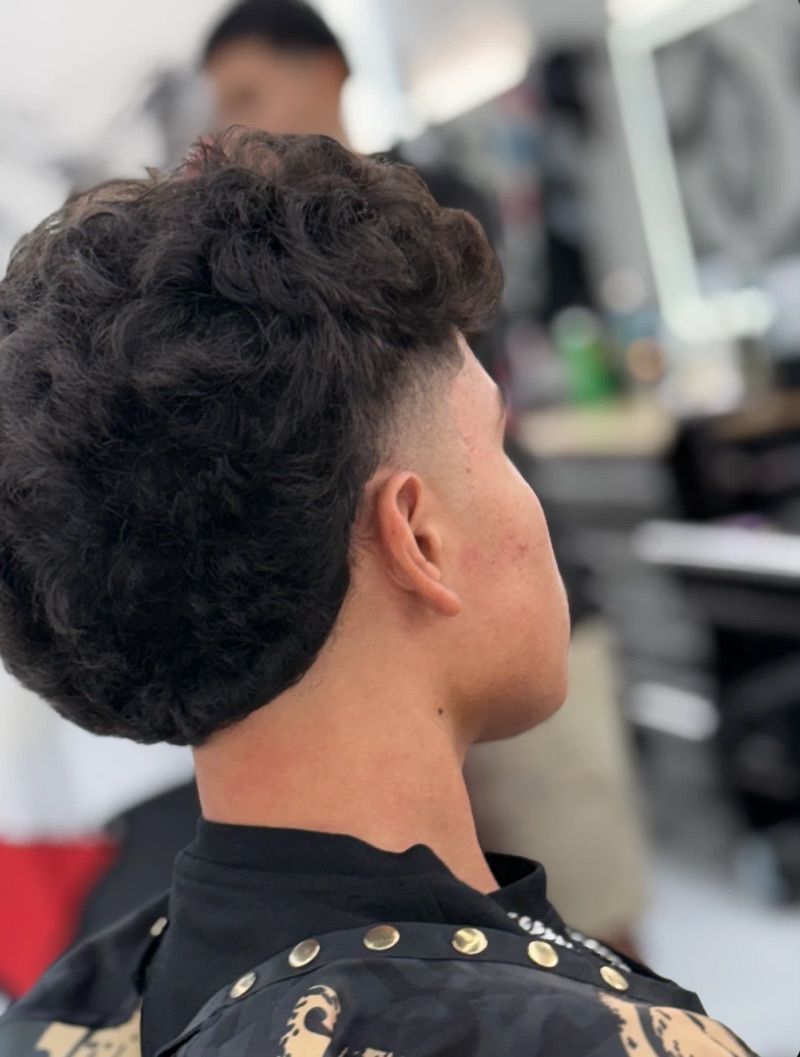 Back view of a drop fade blended into a full curly top